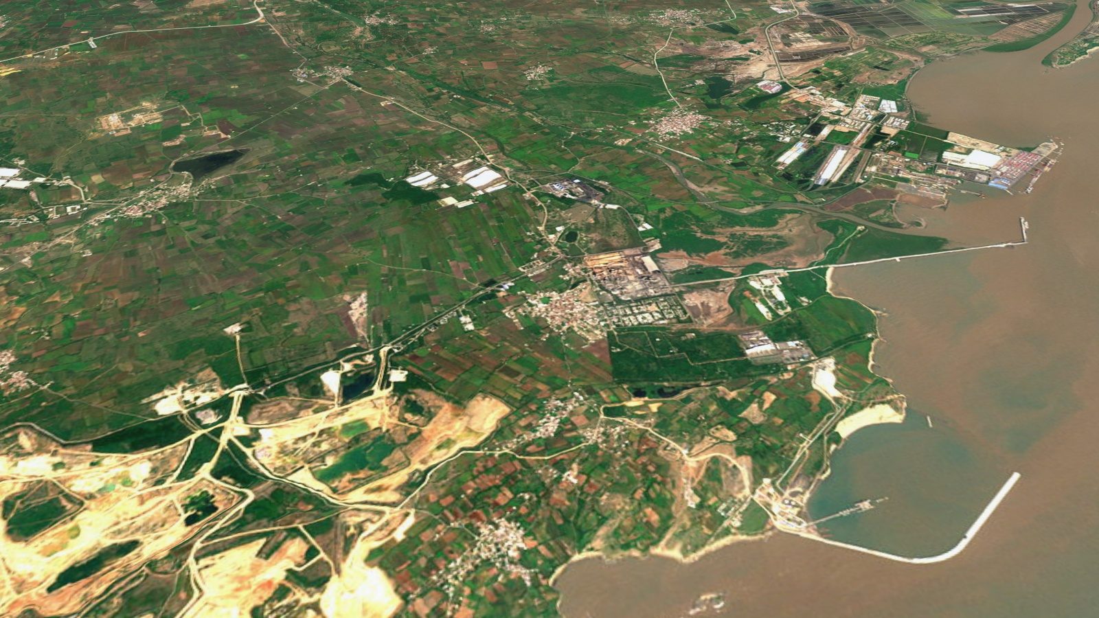 The coast from the air: Kovaya from the air. The village is in the middle, the cement works to its right, the white pits to its left.